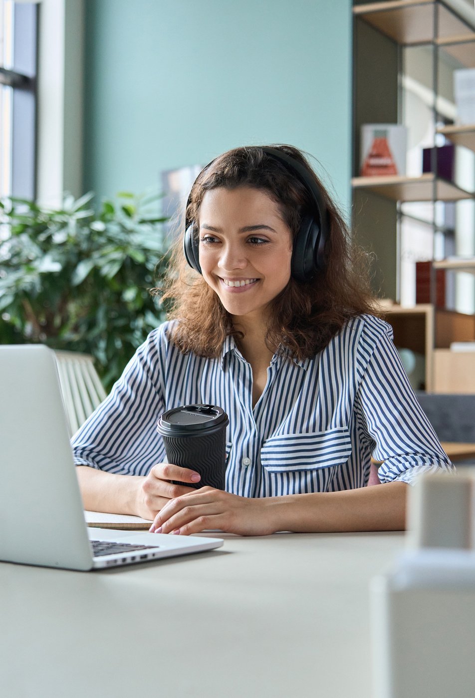 Woman Using Laptop and Headphones for Videoconference